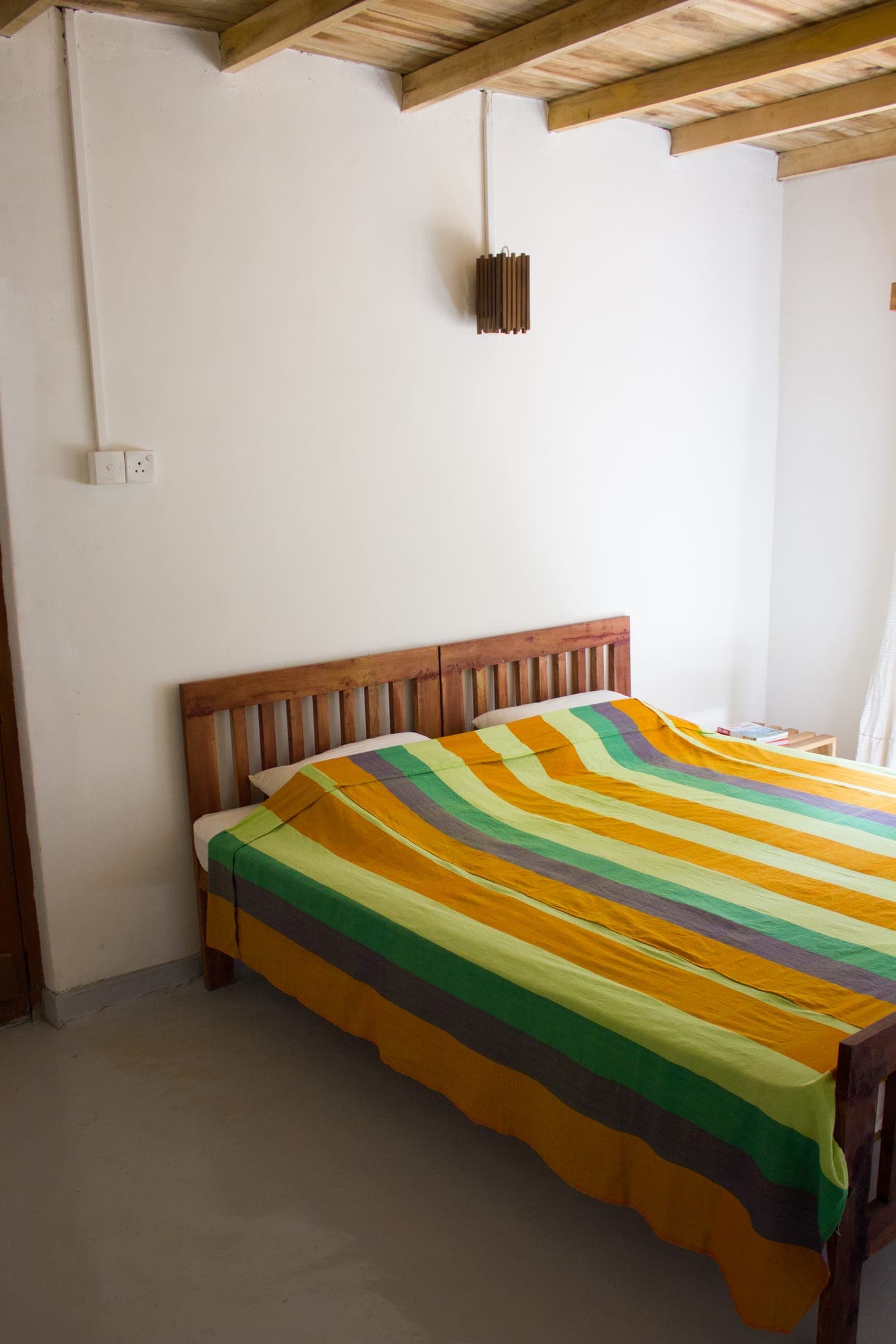 Bedroom with a double bed made up in a striped Sri Lankan cotton bedspread