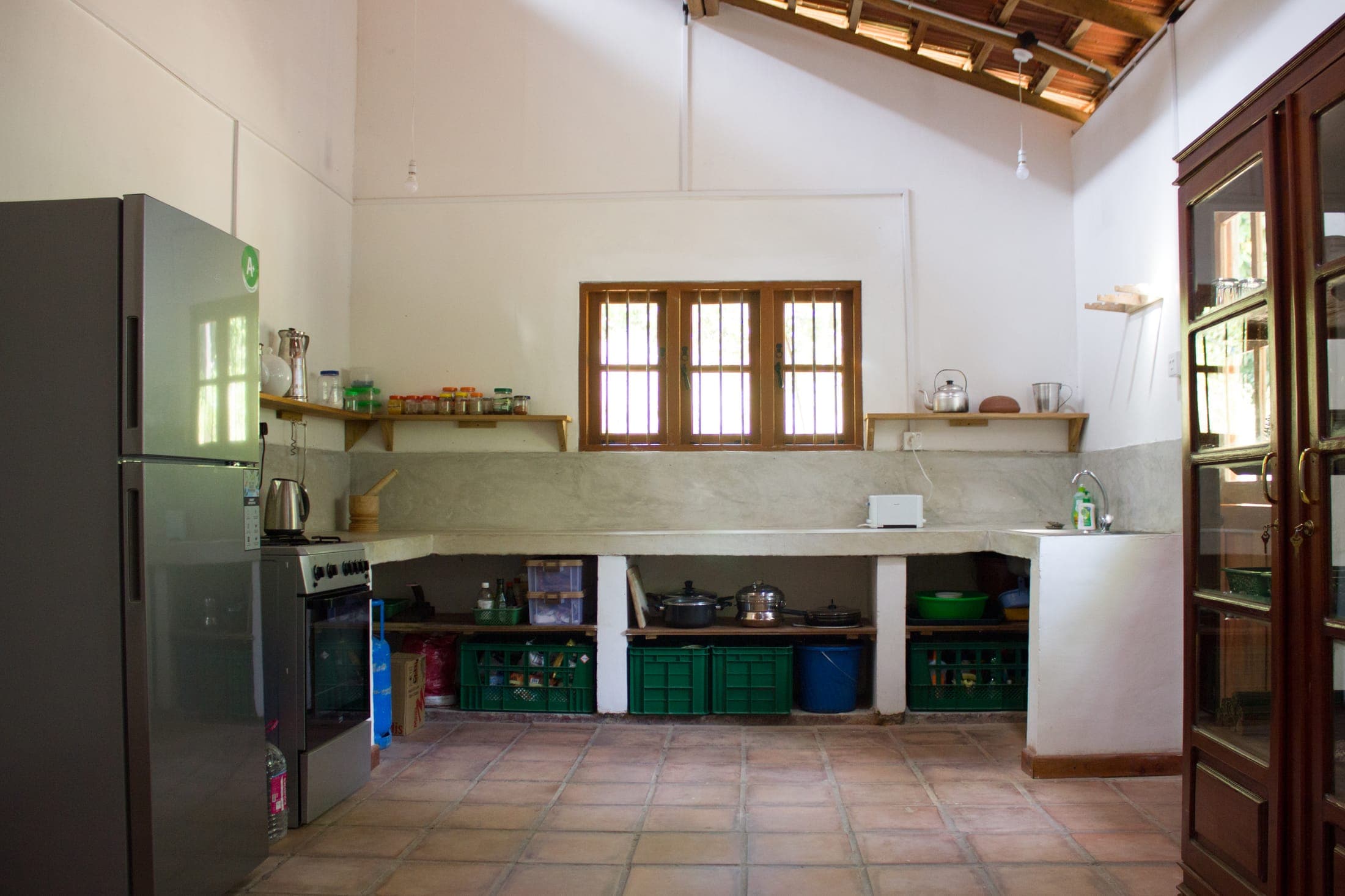 The well-equipped kitchen with gas cooker, fridge and a long concrete counter