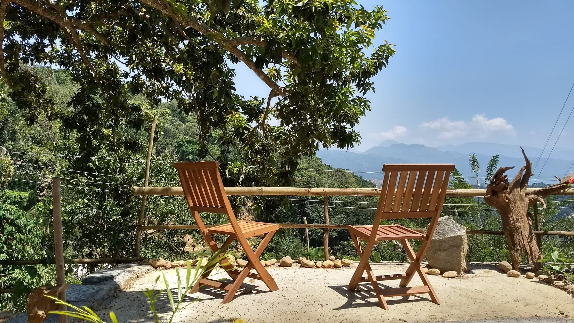 Two wooden deck chairs on the terrace looking out over the valley