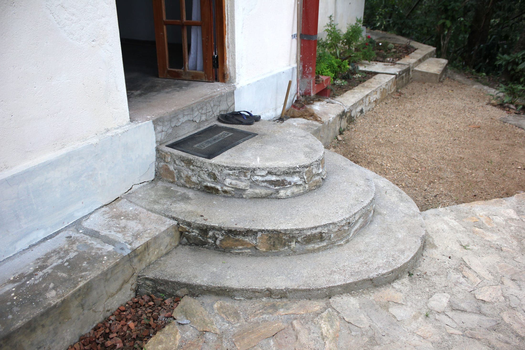 Curved stone steps leading from the cottage door to the terrace