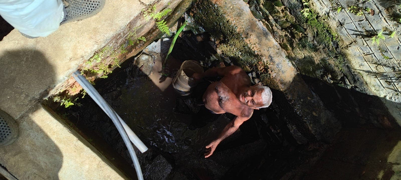 Cleaning out the old stone well on the estate by hand