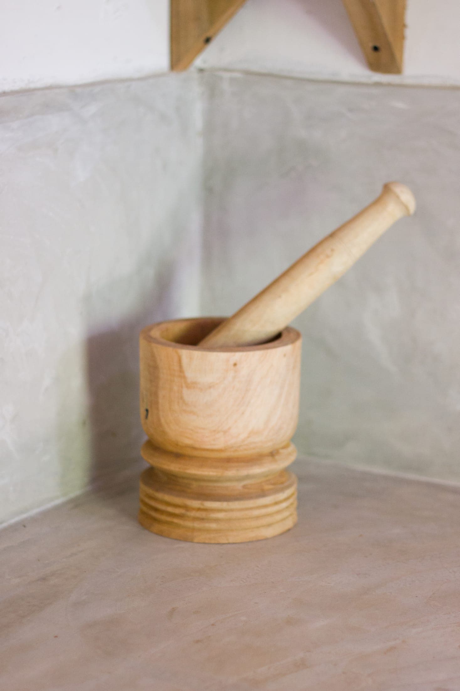A traditional wooden mortar and pestle used for grinding spices