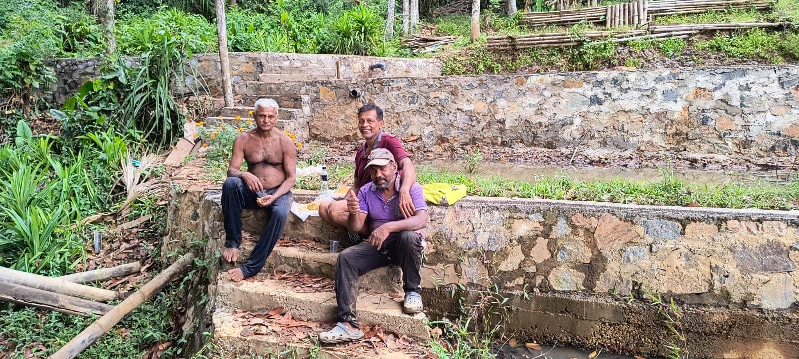 Neighbours taking a break together on the stone steps beside the ponds