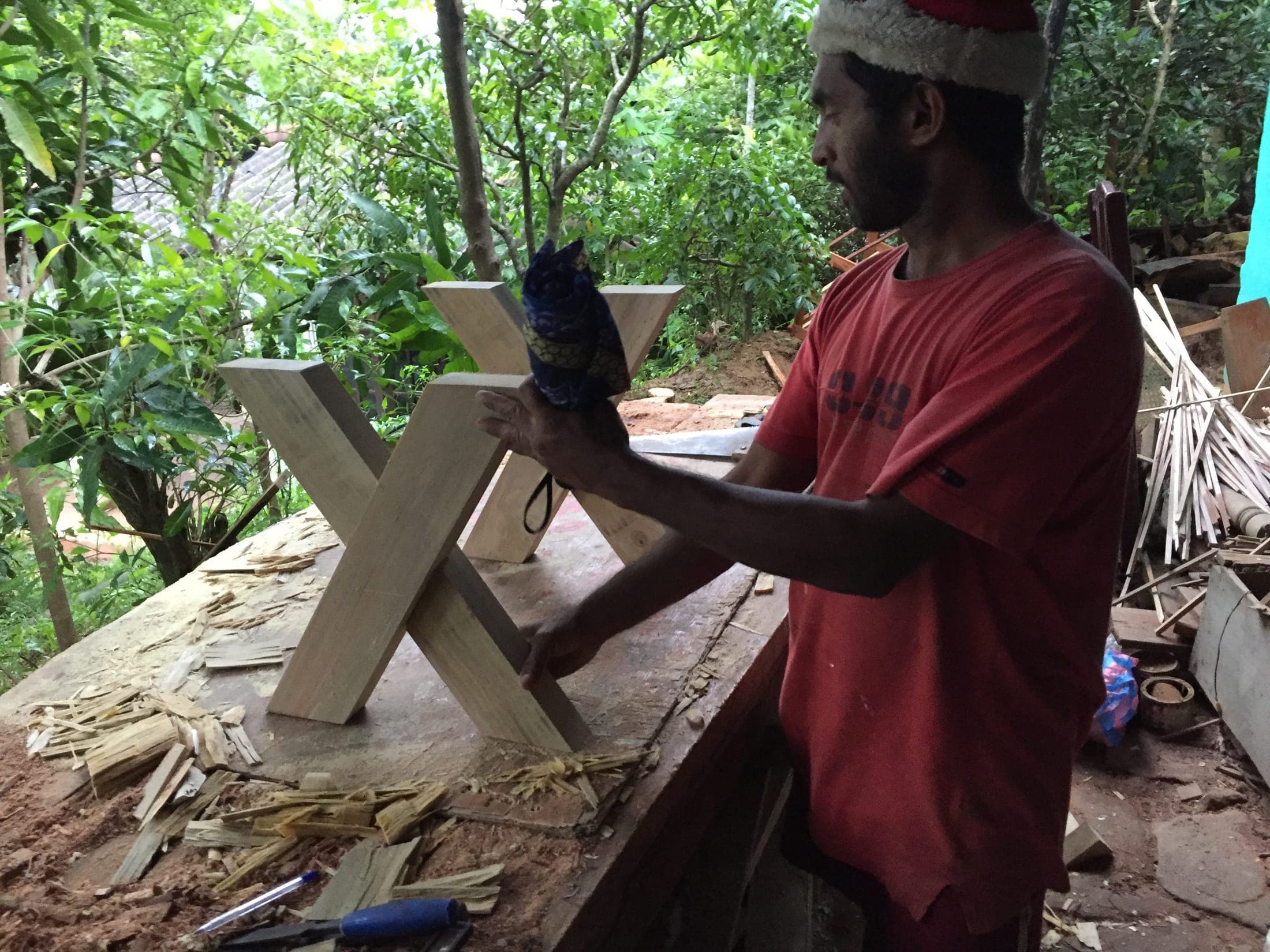 Rukman, the village carpenter, sanding a table leg in his workshop