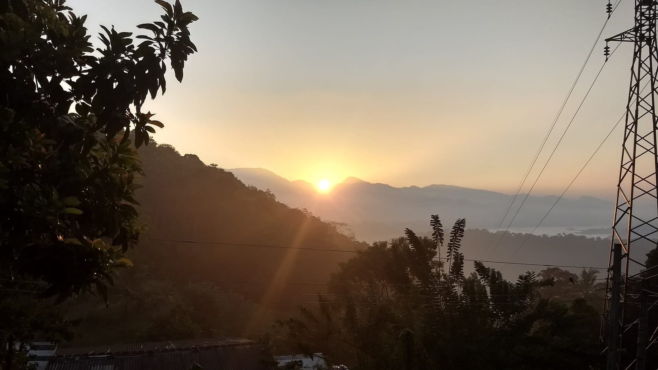 Sunrise over forested hills and Victoria Lake, seen from the cottage terrace